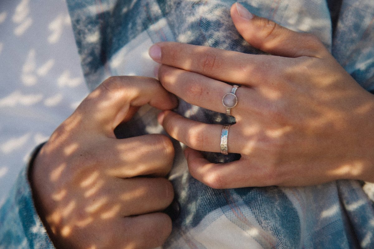 Close-up of a couple's hands touching during their vow exchange